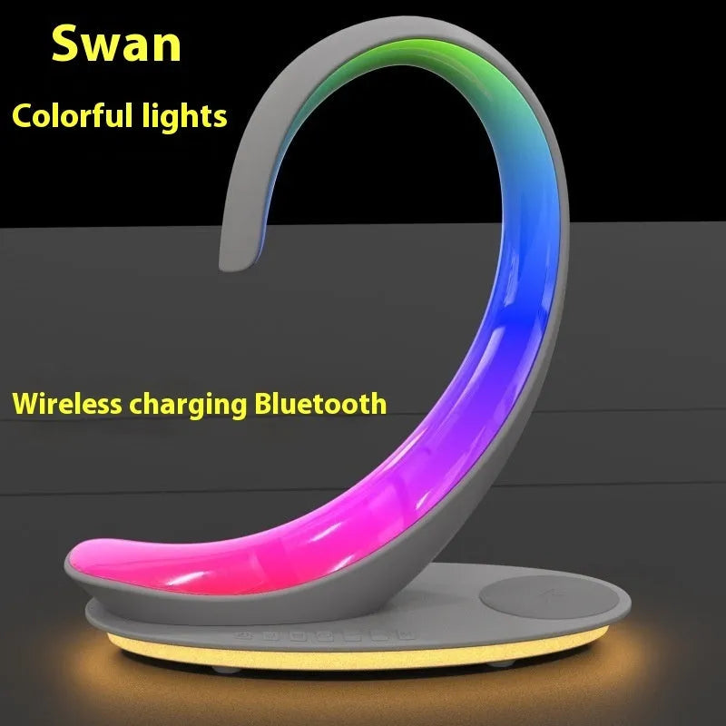 White swan-shaped desktop wireless charger with integrated Bluetooth speaker and colourful LED atmosphere light.