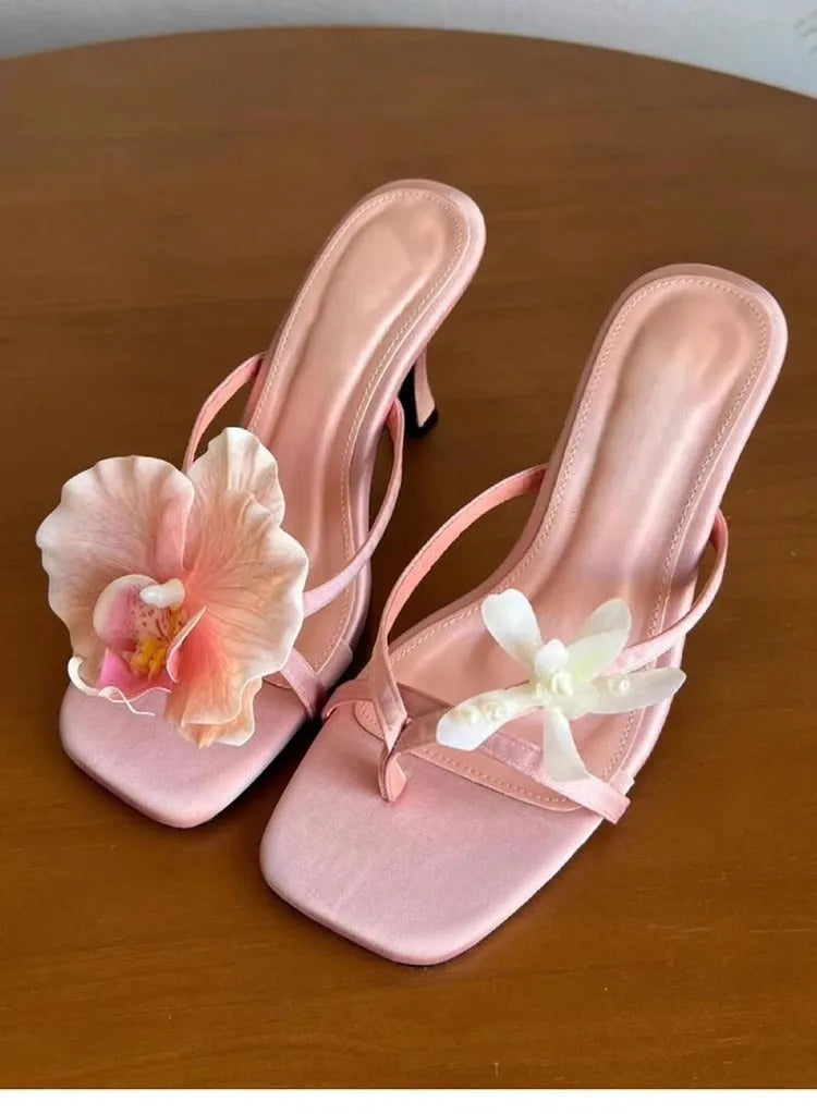 Handmade women's asymmetric flower sandals with high heel and square toe in black leather.