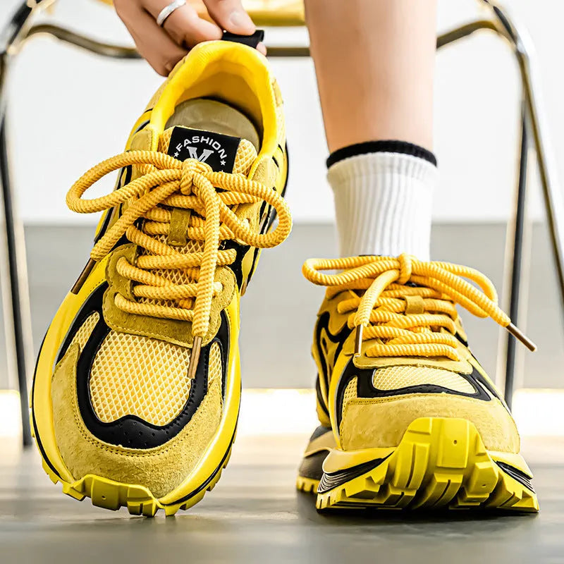 Men's casual sneaker in synthetic leather and mesh, showing round toe and lace-up front.