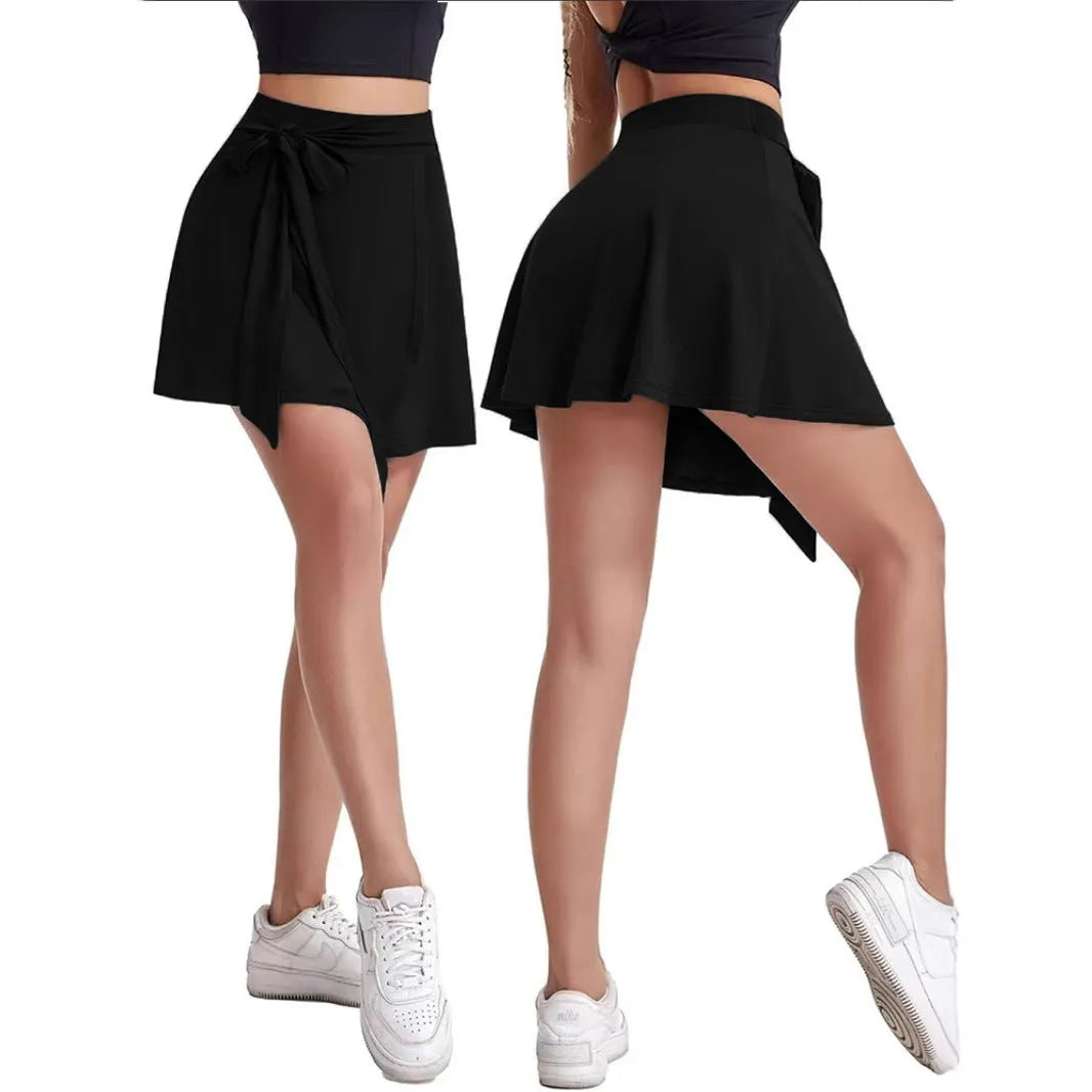Black thigh-length sports skirt with built-in shorts, high waist, and shoulder strap details.