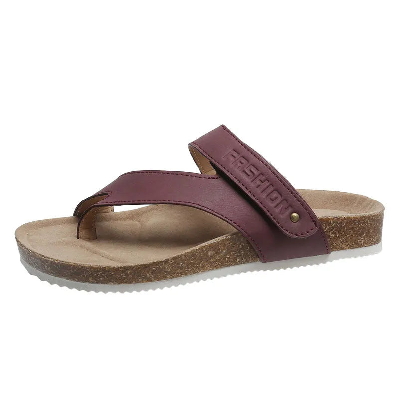 Flat toe ring flip-flops with a thick foam sole in a solid blue colour on a sandy beach.