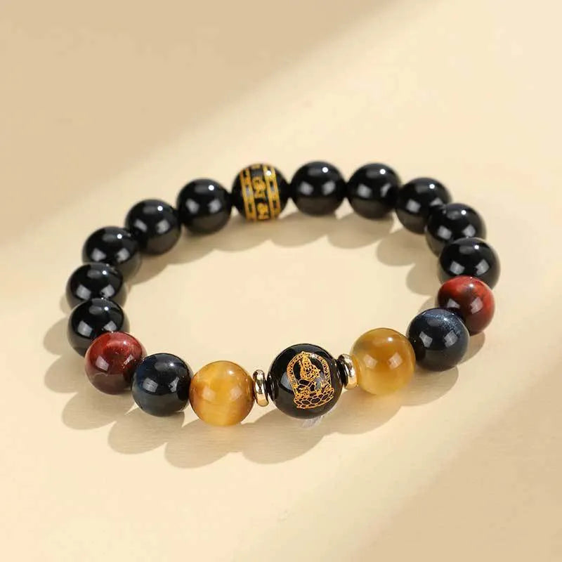 Handmade black agate beaded bracelet with gold, blue, and red tiger eye stones featuring Buddhist deity and zodiac animal motifs.