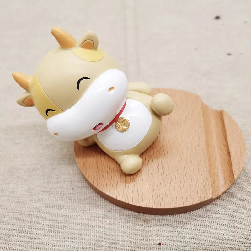 A decorative resin mobile phone stand holding a smartphone, shown in an animal design variant.