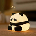 Cartoon panda silicone night light with USB charging cable on wooden surface