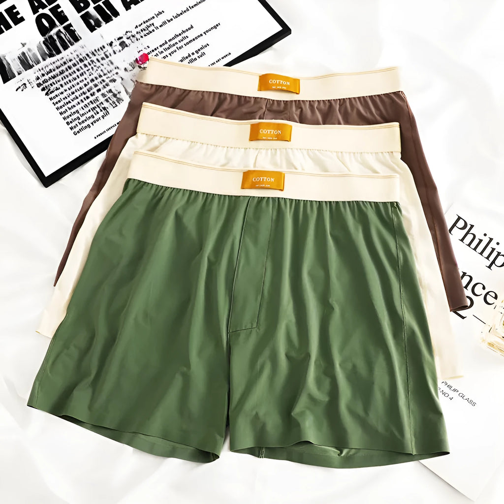 Men's solid colour loose ice silk underwear in beige, black, and grey shades laid flat