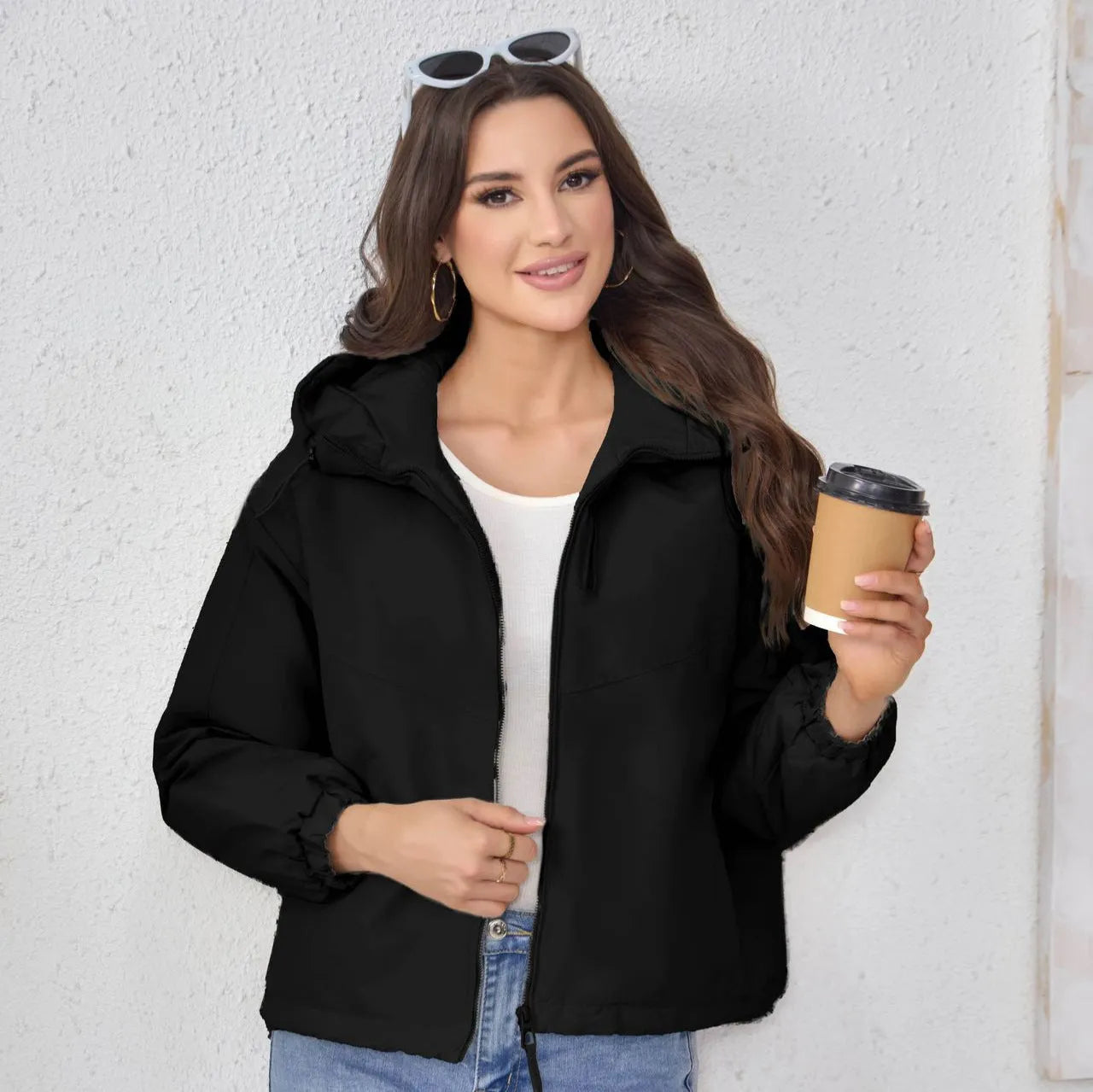 Grey loose-fit women's hooded shell jacket with long sleeves on a hanger.