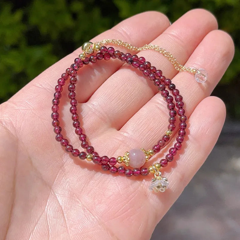 Close-up of a women's double ring bracelet made with natural garnet stones in H311 colour.