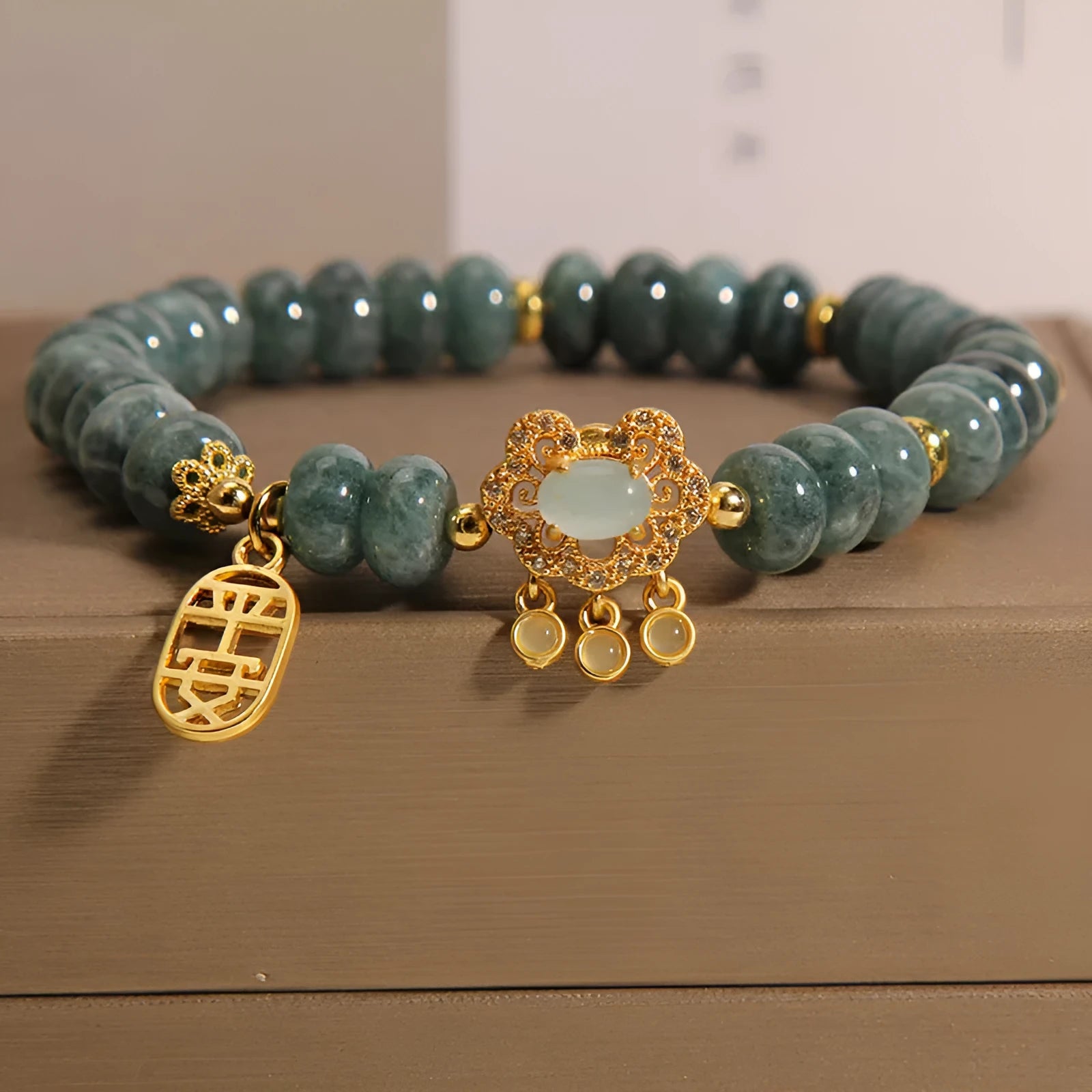Women's bracelet with green jade abacus beads and a metallic safety lock clasp.