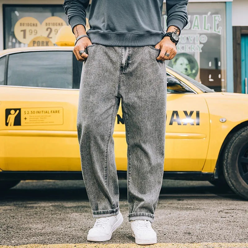 Men's dark blue loose straight-leg cotton jeans on a hanger, showing the simple style and mid-waist fit.