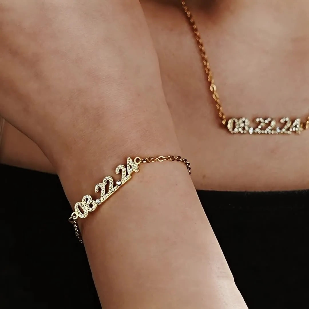 Stainless steel digital bracelet watch with diamond-set numbers on the face, shown in gold tone.