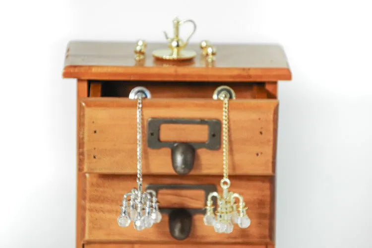 A small gold or silver metal photo prop decoration measuring 5 by 2 centimetres.