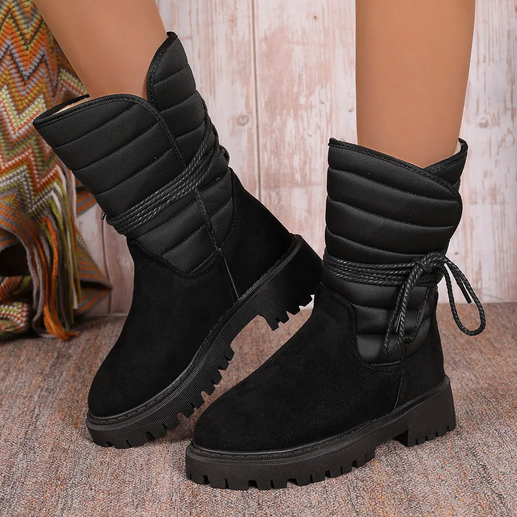 Women's black suede high-top snow boots with chunky rubber sole and lace-up design.
