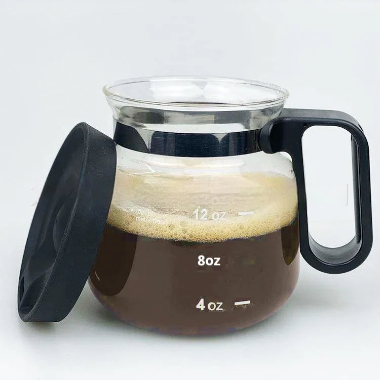 Transparent borosilicate glass coffee maker with a black silicone cover on a kitchen counter.