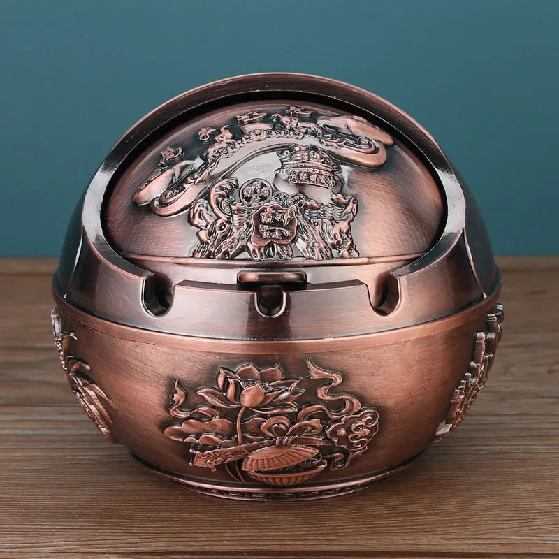 Alloy decorative ashtray in bronze with ornate peacock motif and cigarette extinguishing slot.