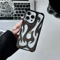 Silver electroplated iPhone case with hollow flame pattern design on a table
