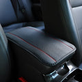 Automotive fibre leather embossed armrest box mat measuring 32x19cm in black with red cords colour
