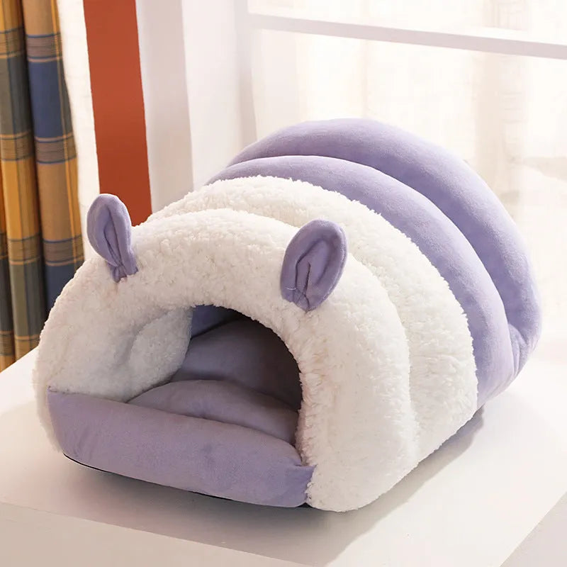 Closed cat nest bed in blue colour with removable cushion shown in home setting