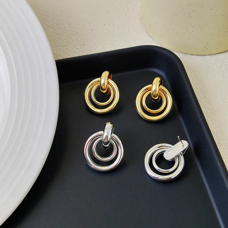 Geometric round ring earrings with irregular shape in gold electroplated finish on mixed material