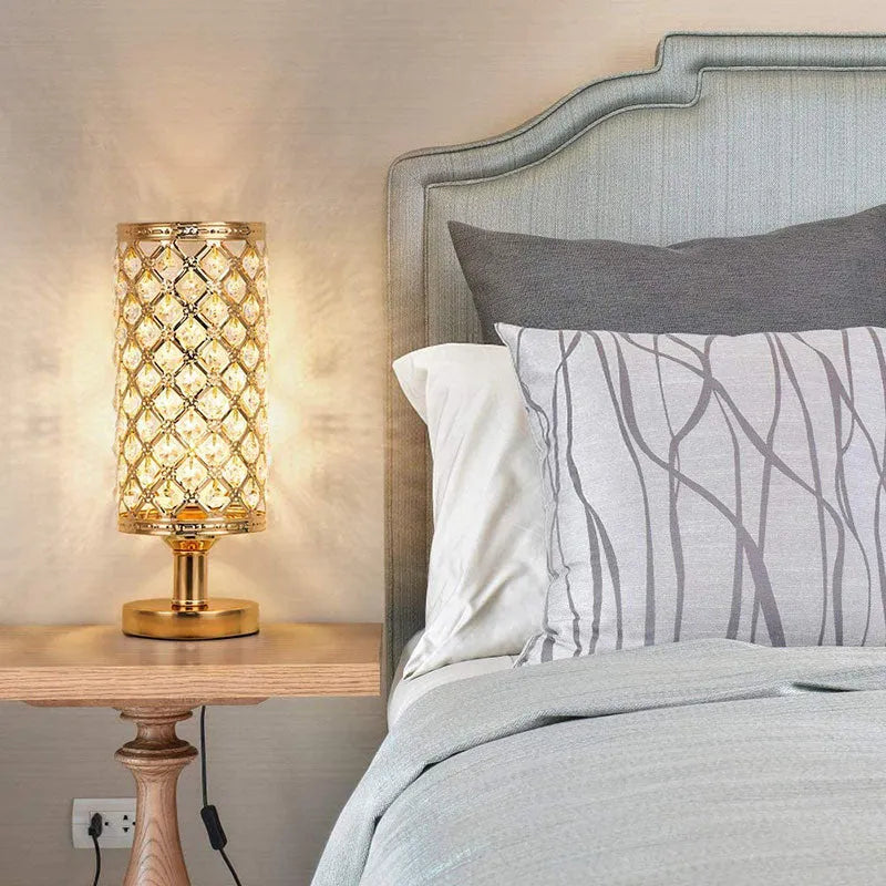 Modern crystal table lamp with hollow-carved design, metal base, gold finish, on bedside table