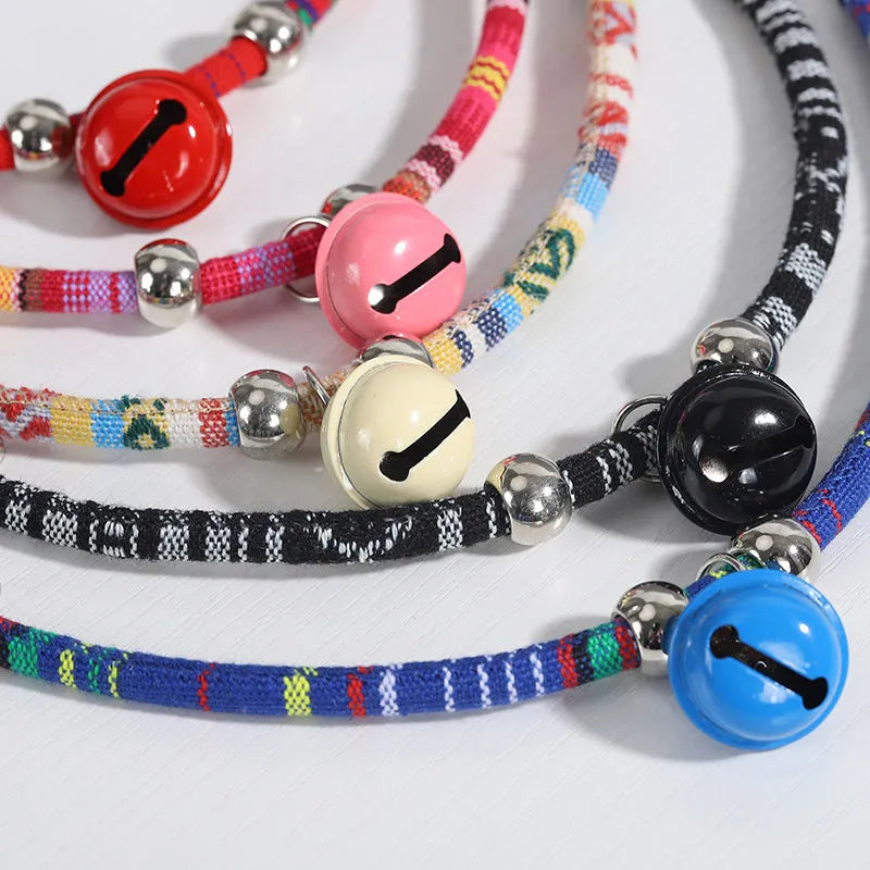 Adjustable ethnic-pattern pet collar with metal bell in blue, showing buckle and size tag.