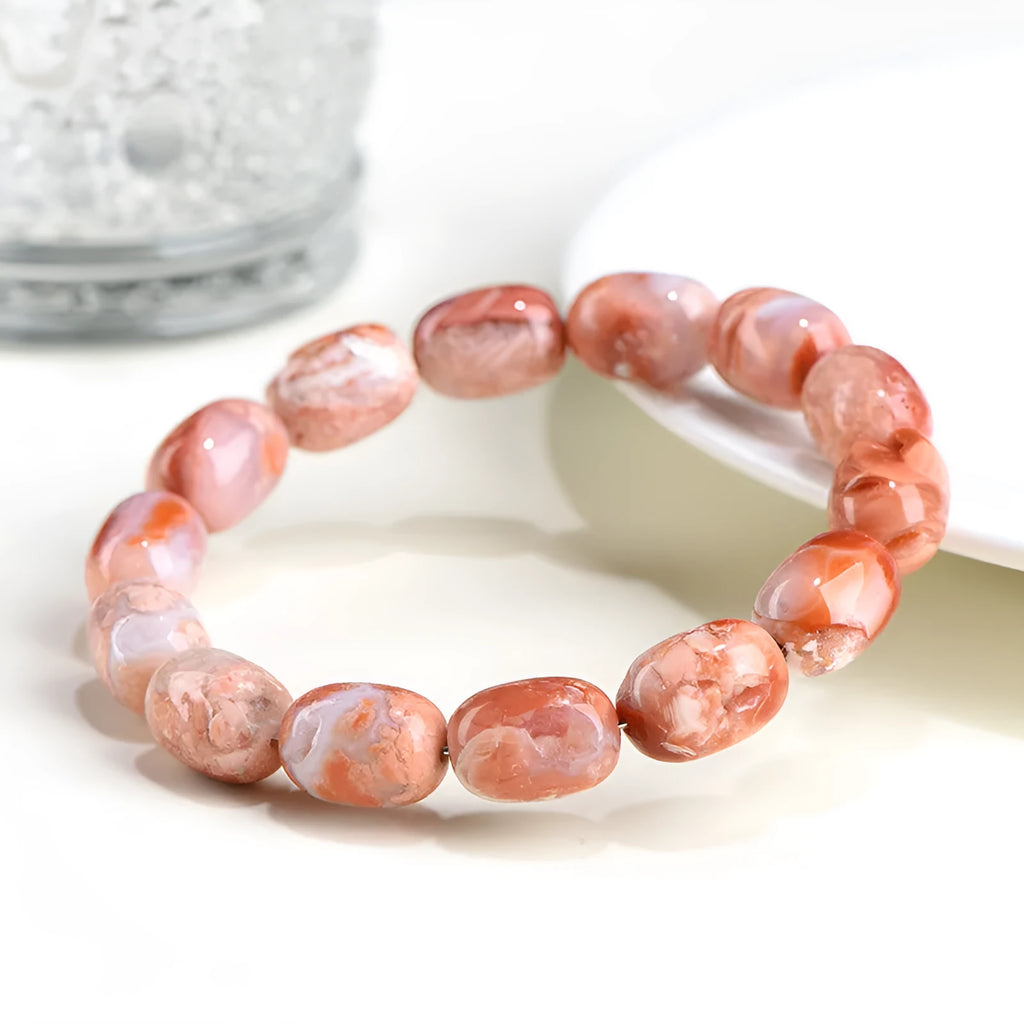 Natural cherry agate bracelet with geometric 10x14mm barrel beads and ruyi details on a wrist.