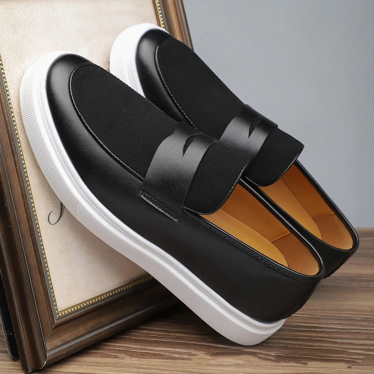 Men's black slip-on casual Gommino-style shoes with round toe and tassel decoration on a flat mid-heel.