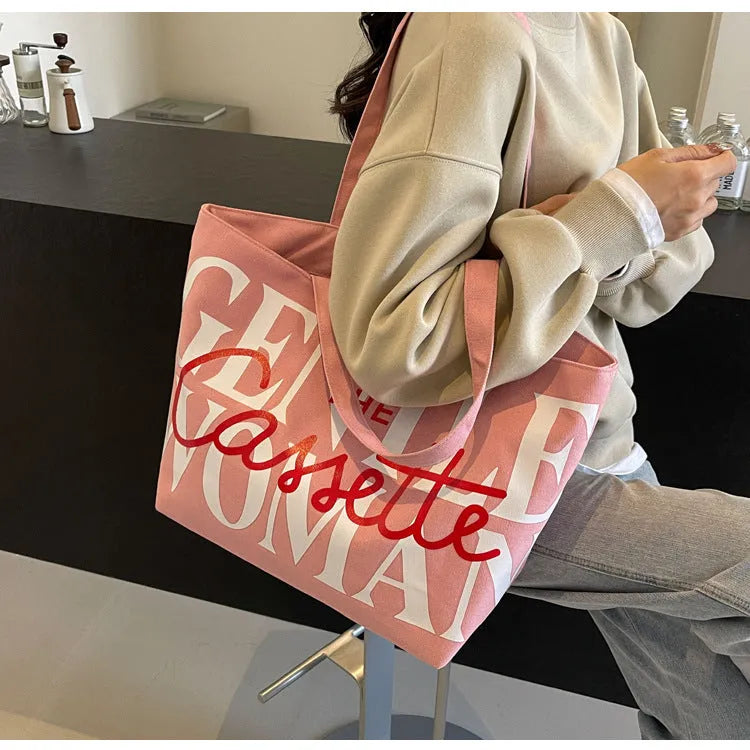 Canvas tote bag with letter print and car stitching detail in medium size 40x7x32cm available in black