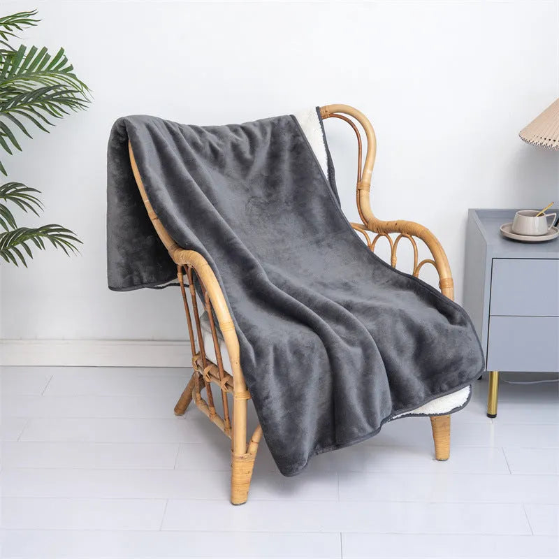Grey lambswool waterproof dog blanket on a sofa, showing its cloth texture and size.