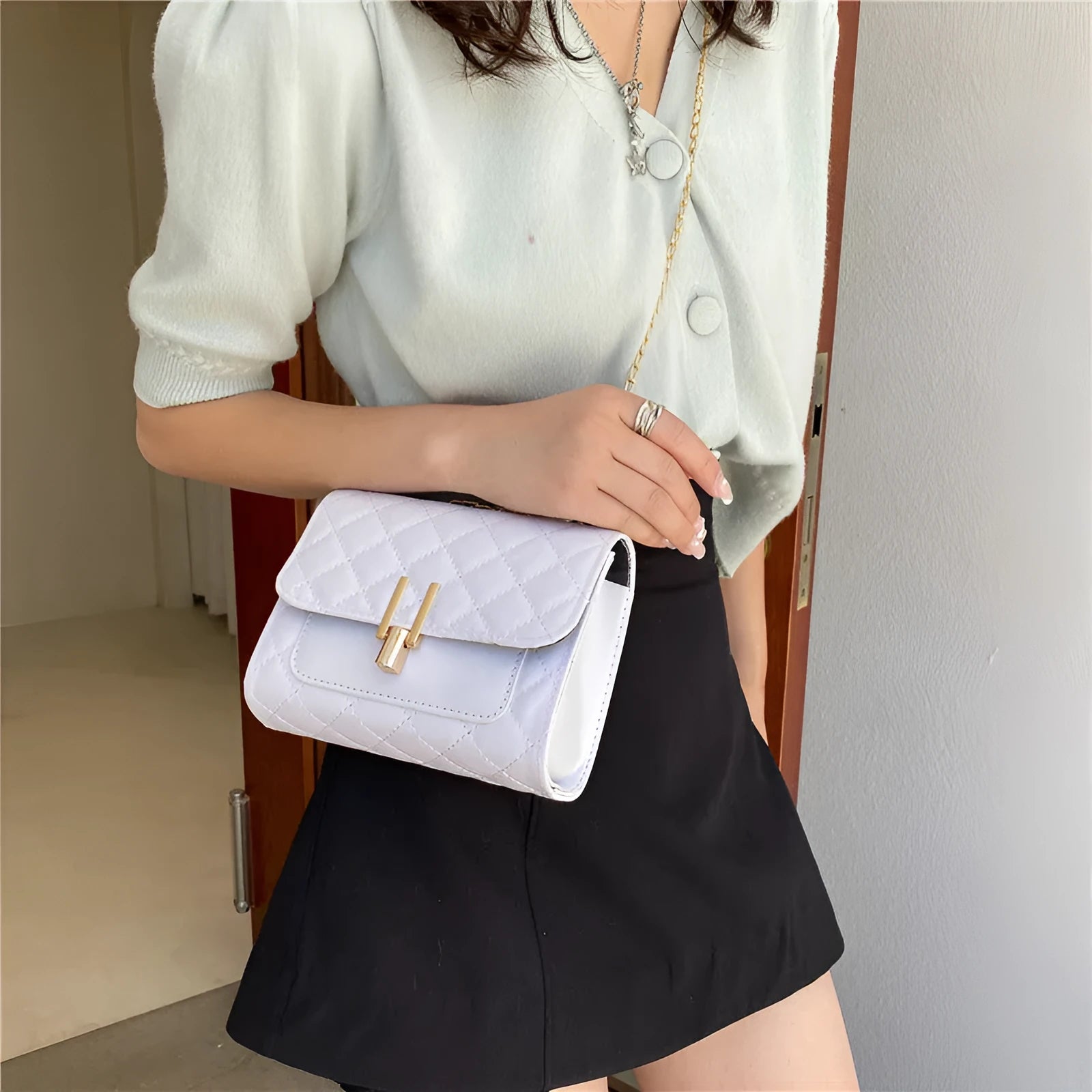Women's minimalist crossbody bag with diamond lattice chain strap in black, green, or white.