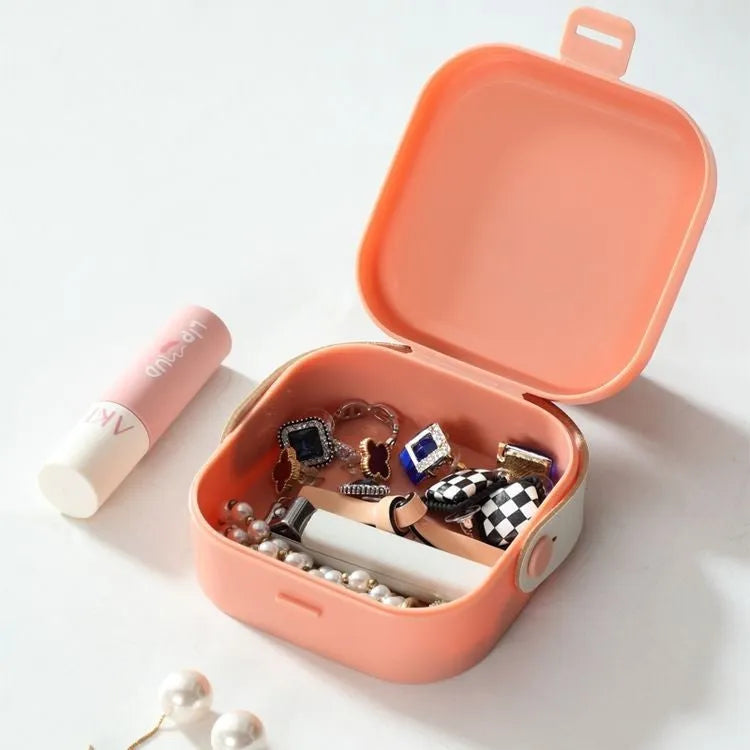 Medium-sized solid colour portable storage box for organising data cables and a Bluetooth headset.