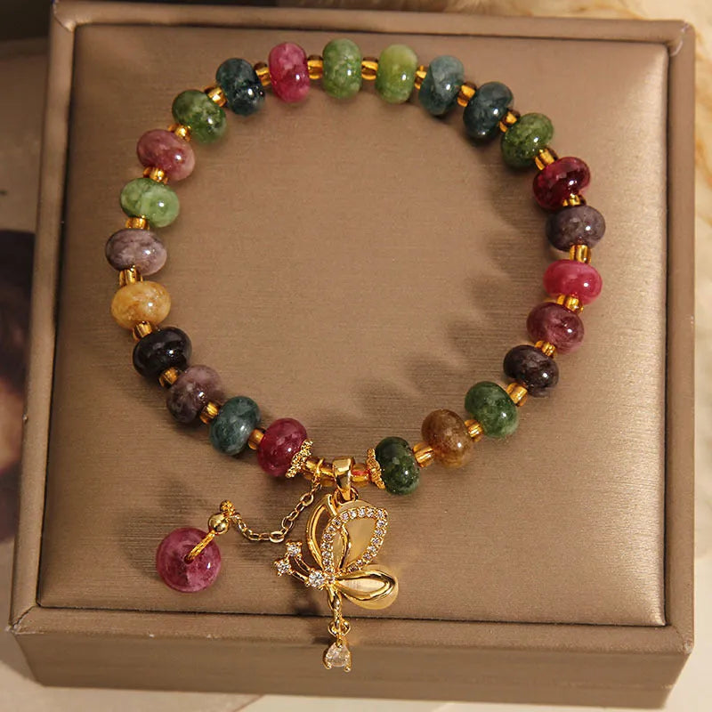 Women's colourful bracelet with alloy butterfly charm and tourmaline beads on wrist.