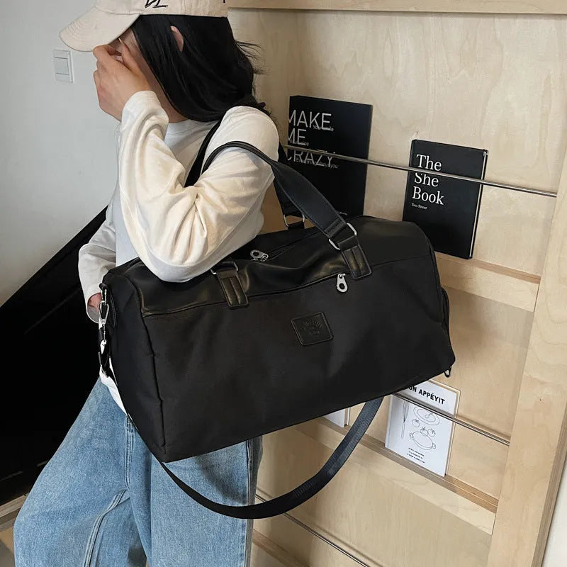 Large black Oxford cloth travel messenger bag showing its spacious main compartment.