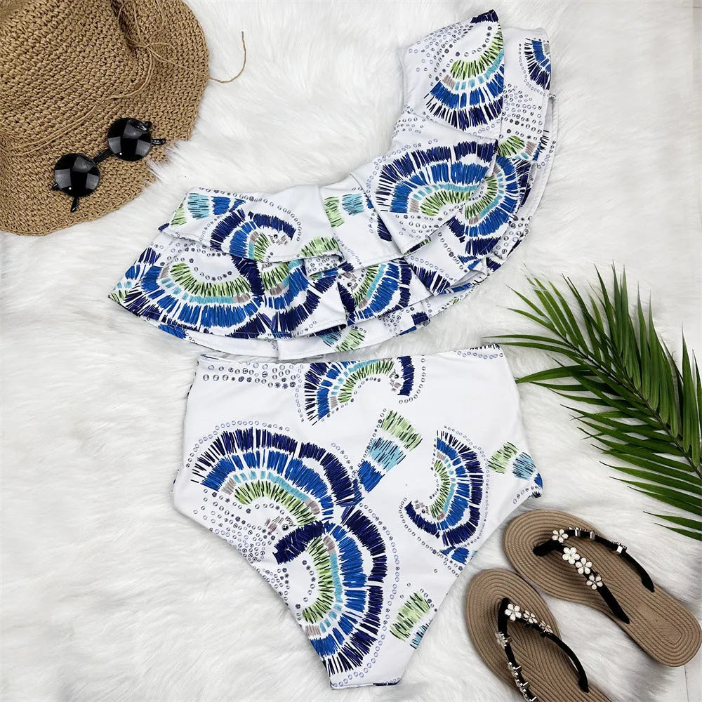 White women's one-shoulder swimsuit with lotus leaf trim and high-leg split.