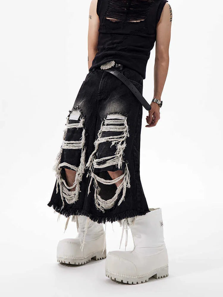 Black wide leg cropped jeans with distressed patch details and a mid-high waist.