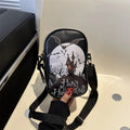 Black mini square crossbody bag with orange pumpkin, white ghost, and black bat graffiti print on the front.