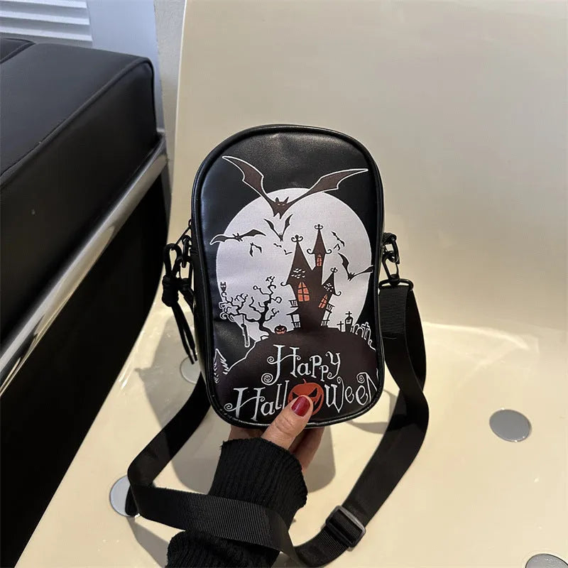 Black mini square crossbody bag with orange pumpkin, white ghost, and black bat graffiti print on the front.