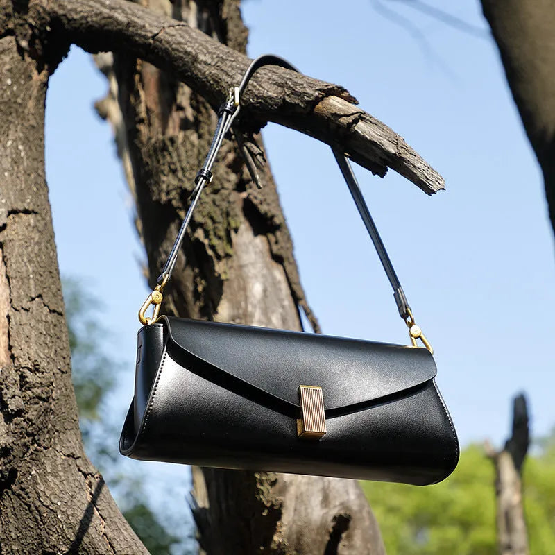 Women's leather cross-body shoulder bag in clamshell design with internal organisers.