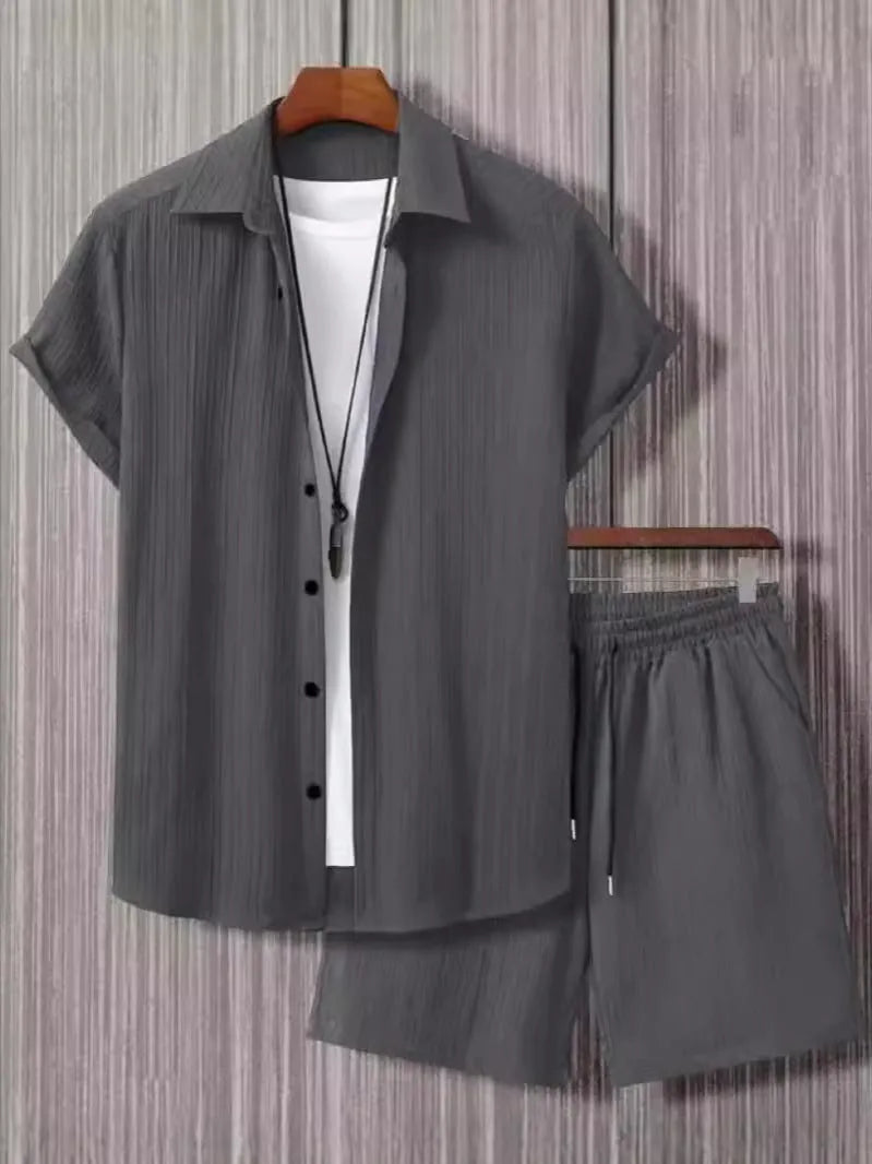 Man wearing a black and white jacquard patterned short sleeve suit shirt with matching formal shorts.