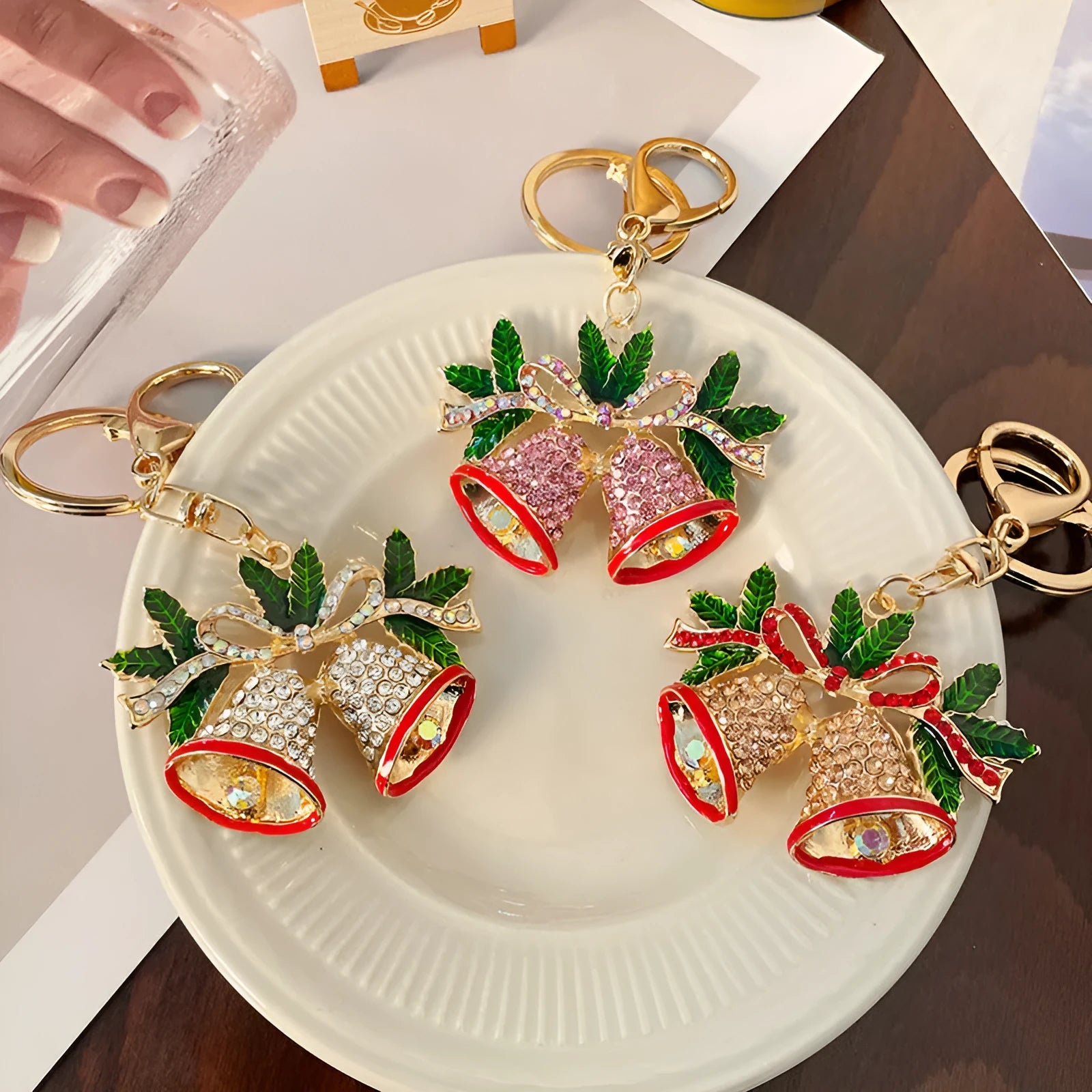 Diamond studded metal Christmas bell keychain in European style on a white background
