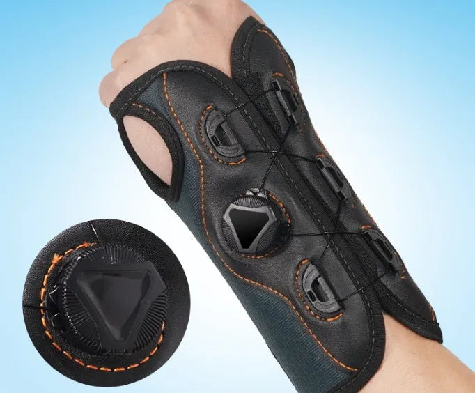 Black adjustable athletic wristguard with rotating pressure system on a flat surface