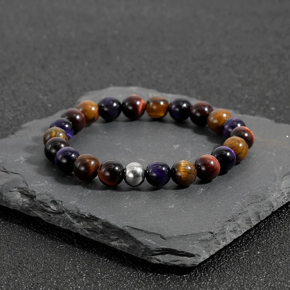 Handmade elastic bracelet with natural tiger-eye stones in geometric cut, yellow purple red colour variations