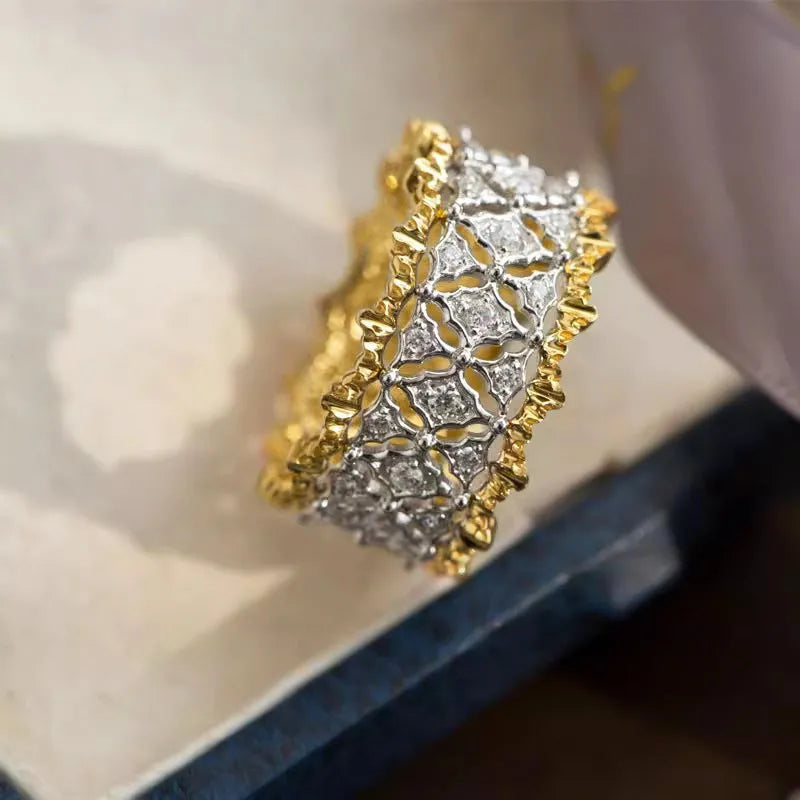 Geometric two-tone copper ring with a round zircon stone, shown on a hand.