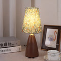 Nordic retro ceramic table lamp with a pleated tapered floral shade on a bedside table.