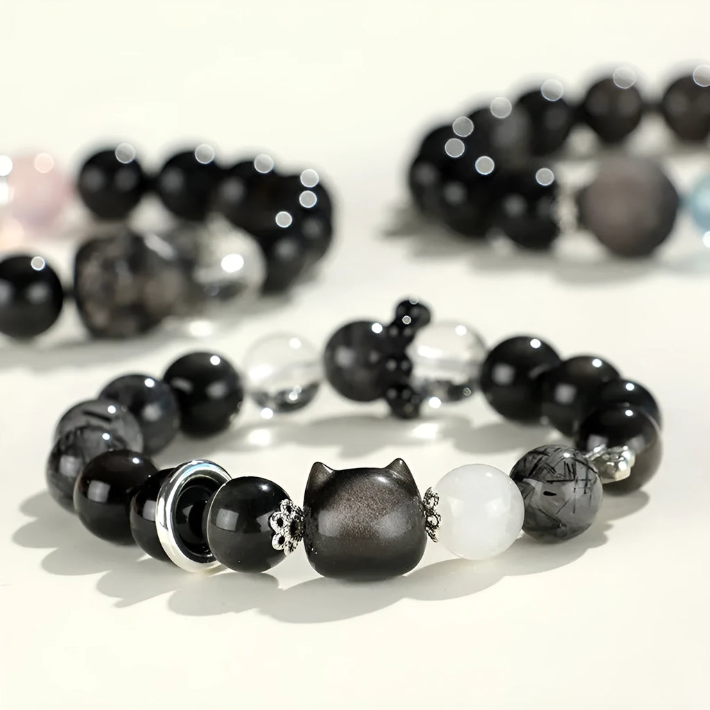 Silverstone crystal beaded bracelet with fox, cat head, and planet charms in white, pink, navy blue, and black.