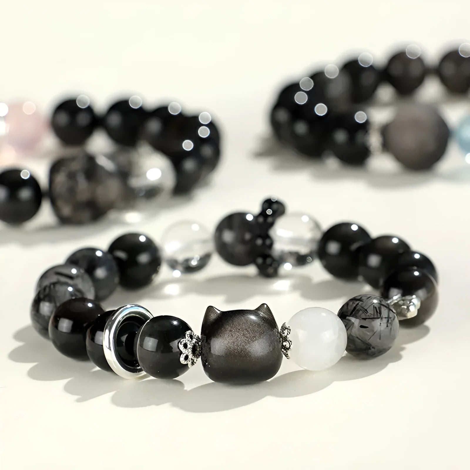 Silverstone crystal beaded bracelet with fox, cat head, and planet charms in white, pink, navy blue, and black.