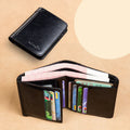 Men's black genuine leather bi-fold wallet open, showing eight card slots, a note compartment, and a zipped coin pouch.