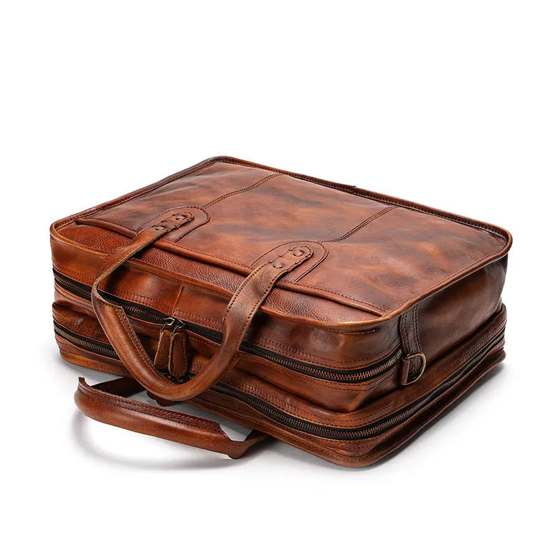 Brown vintage leather men's briefcase showing internal organiser pockets and laptop sleeve.