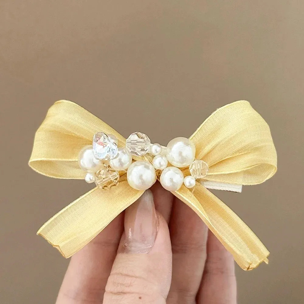 Yellow fabric bow barrette with rhinestone pearls on duckbill hair clip