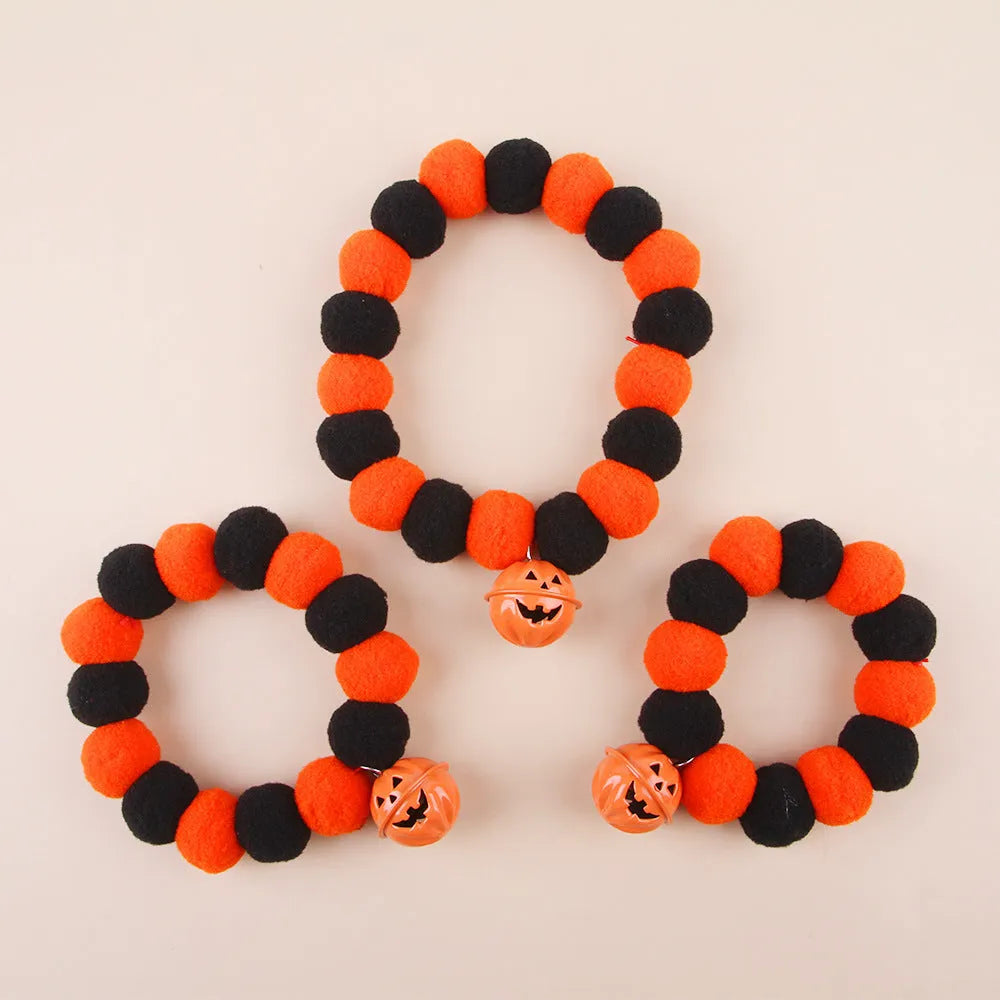 Orange Halloween cat collar with a pumpkin graphic and text, showing the adjustable clasp.