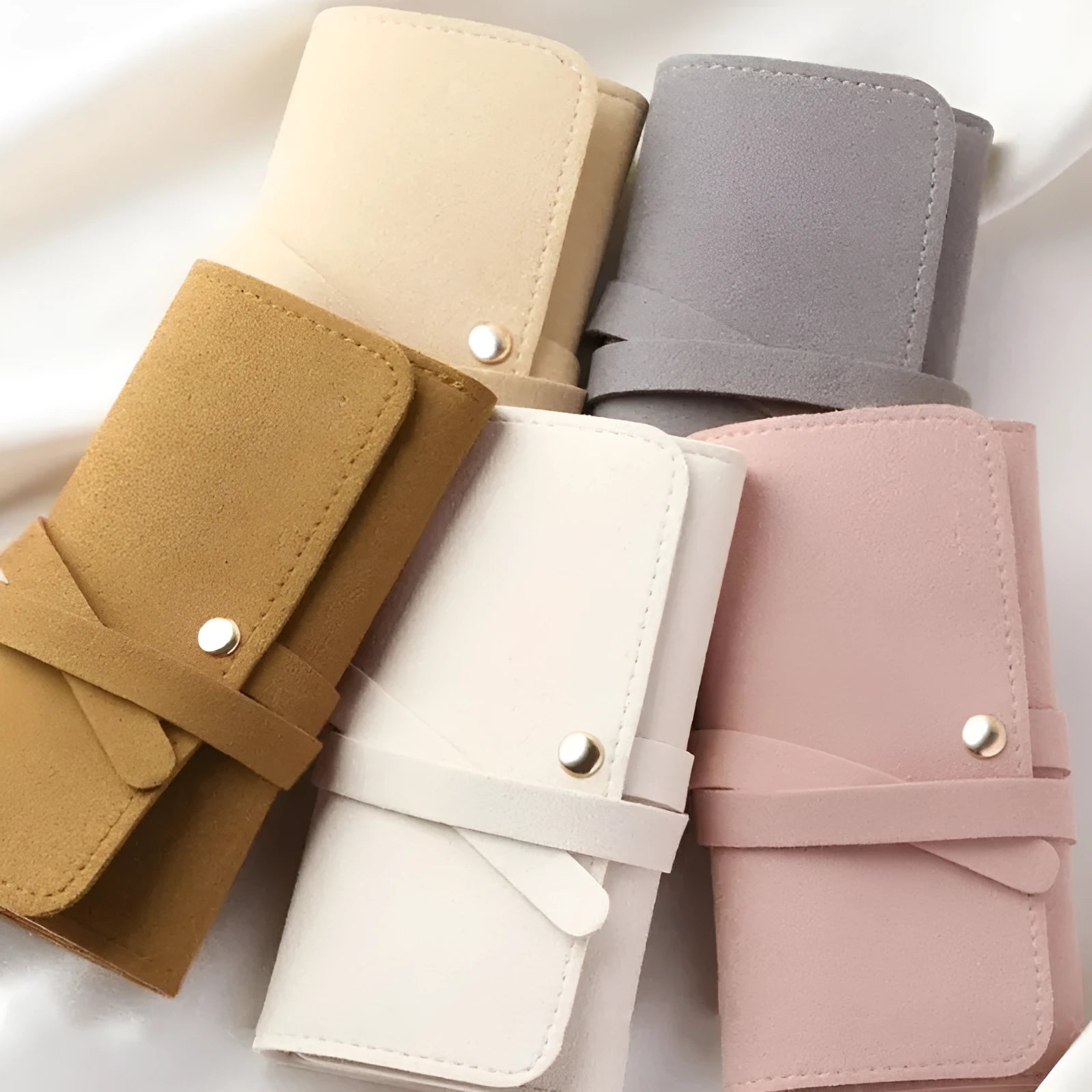 Brown PU leather jewellery storage pouch open to show microfiber lining, with earrings and a ring inside.